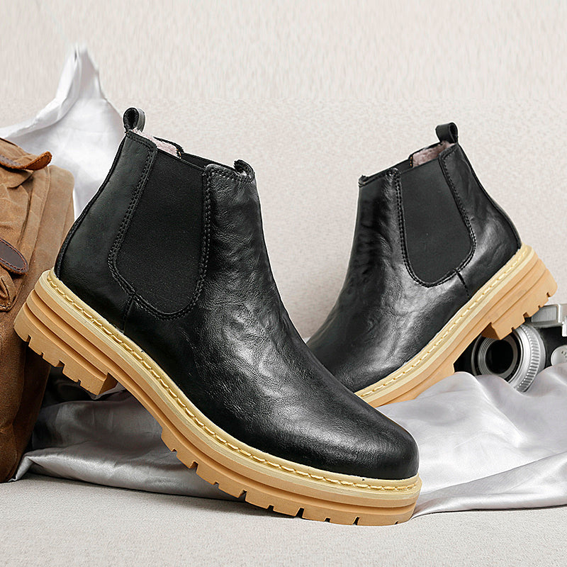 Close-up of men's Chelsea boots, highlighting elastic side panels & pull tab for easy slip-on comfort.