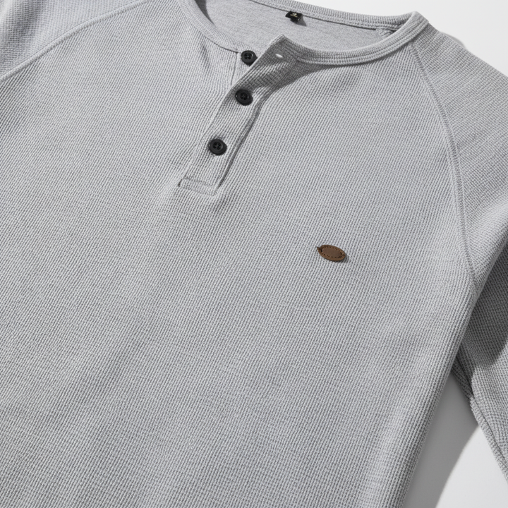 Close-up of the breathable cotton-poly fabric texture of a men's long sleeve button-up shirt, casual.