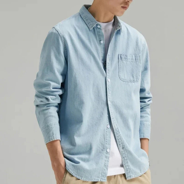 Man wearing a classic fit long sleeve denim button-down shirt for a stylish & versatile casual look.