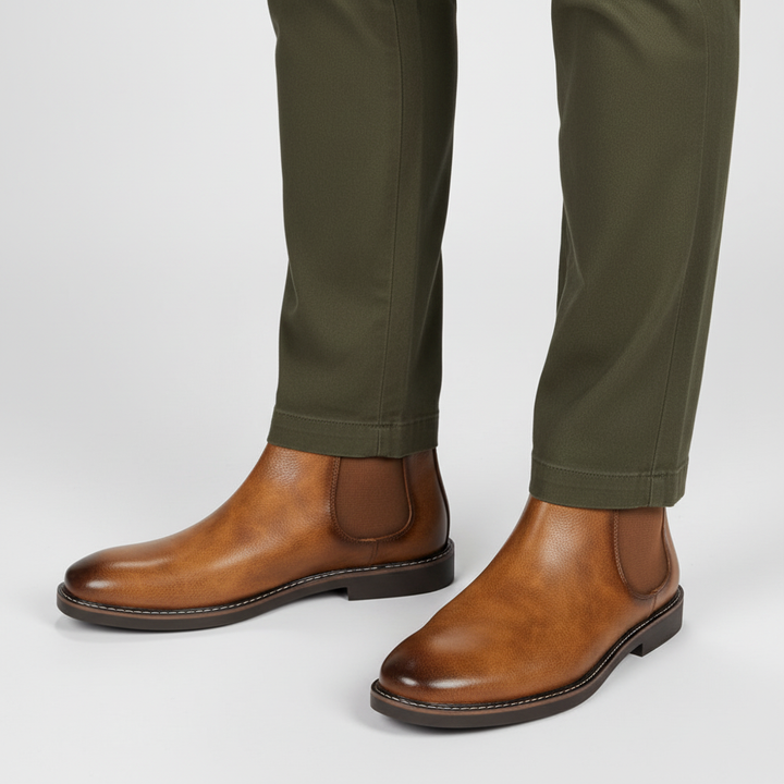 Men's brown leather Chelsea boots on a wooden floor, ready for fall and winter fashion