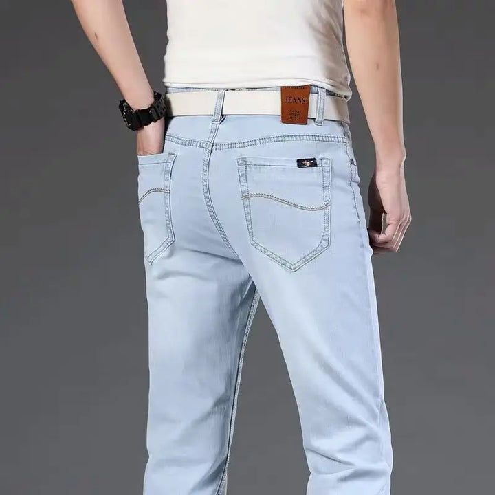 Stack of men's classic fit blue stretch denim jeans, highlighting durable cotton blend and everyday comfort.