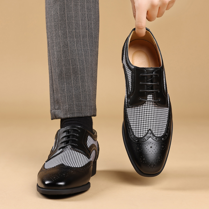 Side view of classic men's dress shoes, showcasing the sophisticated houndstooth pattern & wingtip design.
