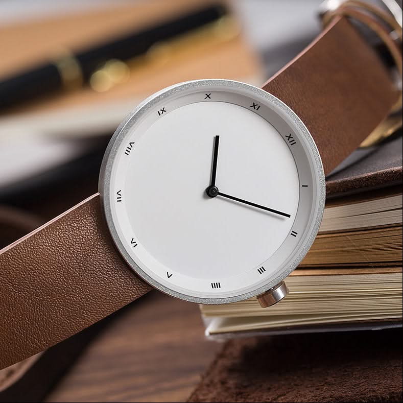 Sleek black dial men's minimalist watch featuring Roman numerals and a sophisticated black strap.