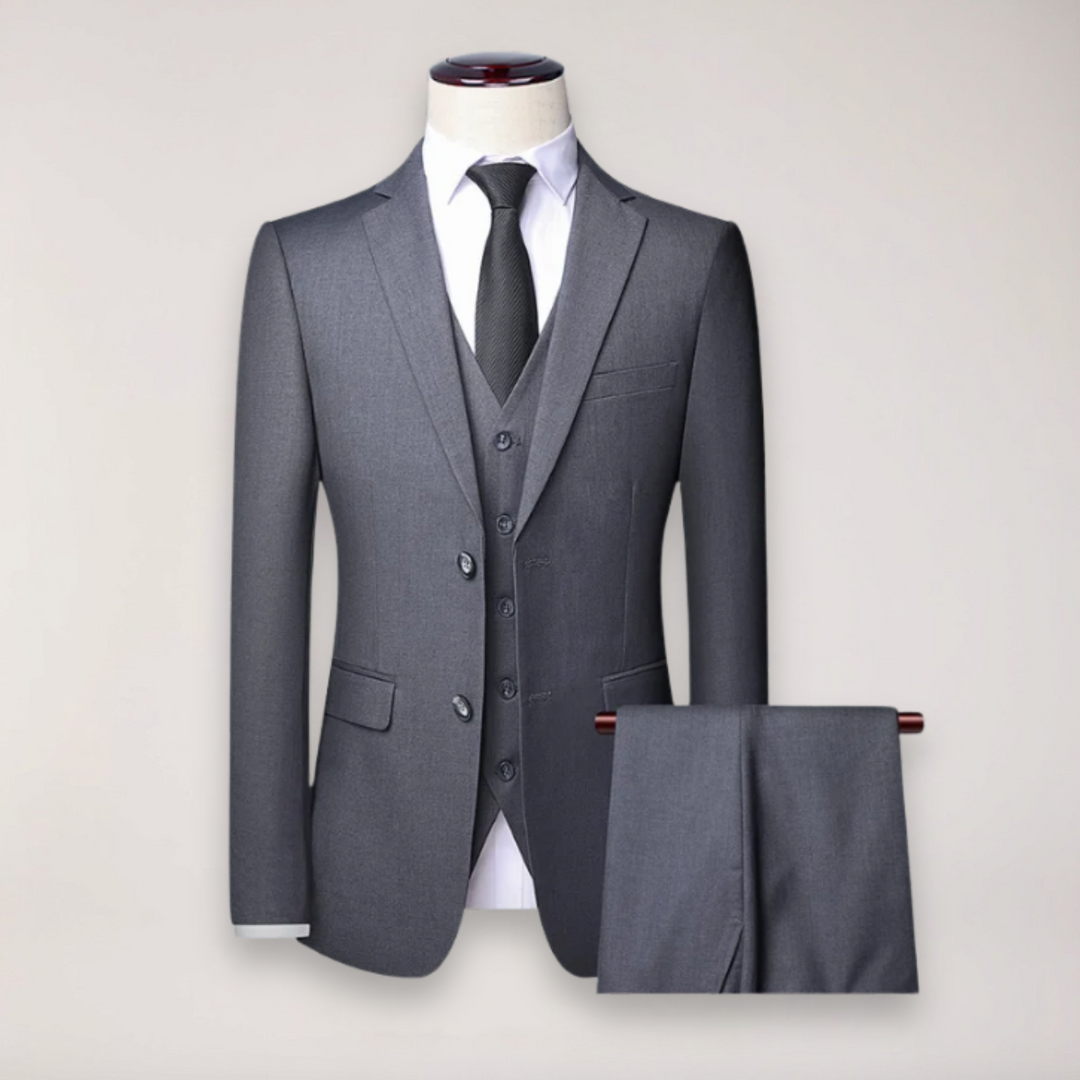 Stylish man in a three-piece formal suit with waistcoat, perfect for a wedding or business event.