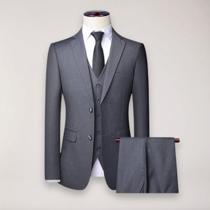 Stylish man in a three-piece formal suit with waistcoat, perfect for a wedding or business event.