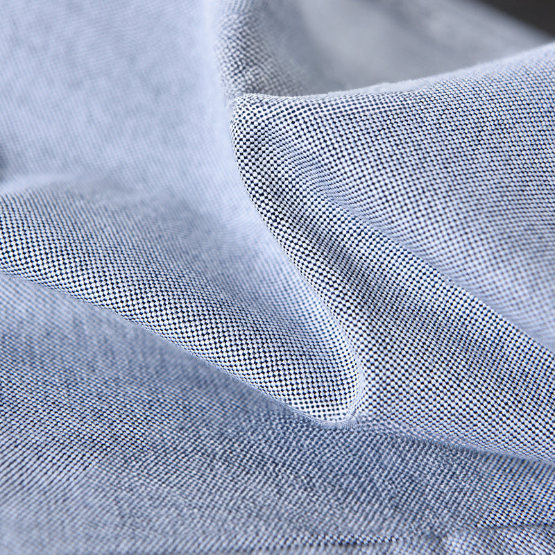 Close-up: Unique ribbon trim detail on collar and cuffs of a men's classic long sleeve Oxford button-down shirt.