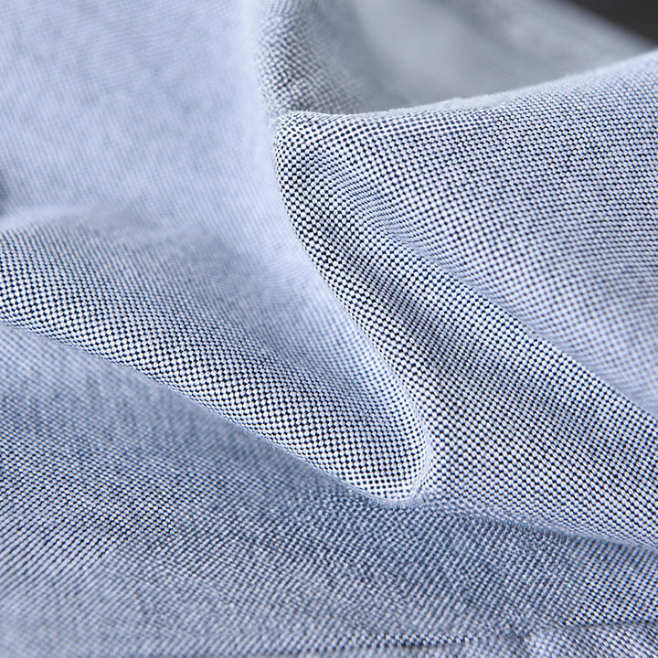 Close-up: Unique ribbon trim detail on collar and cuffs of a men's classic long sleeve Oxford button-down shirt.