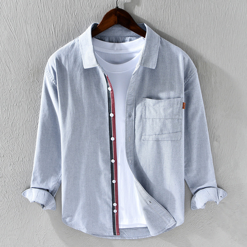 Elegant men's light blue Oxford shirt, button-down. Subtle ribbon accent adds a sophisticated touch. Long sleeve.