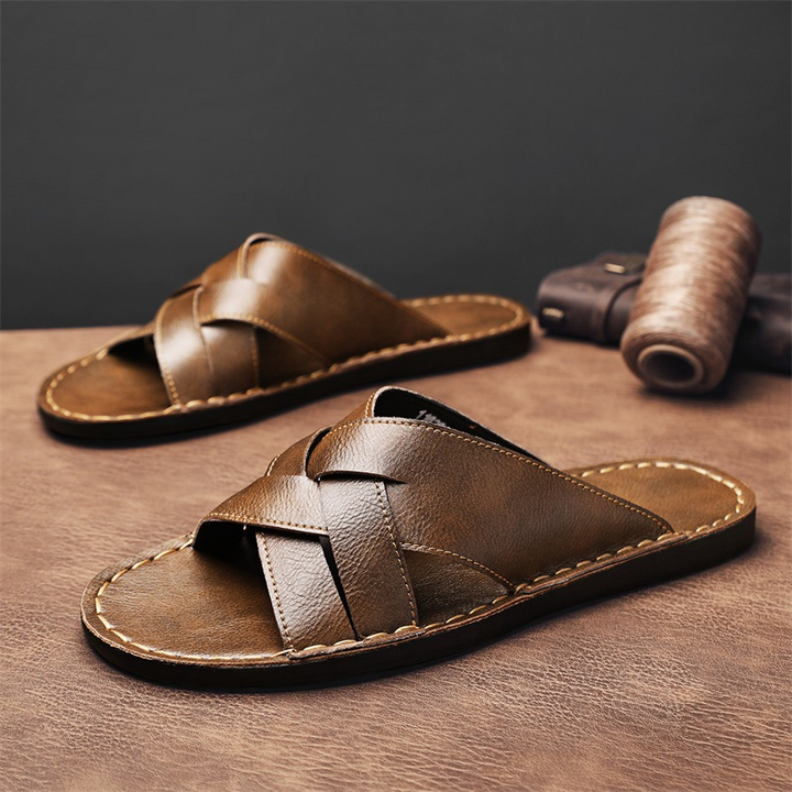 Stylish men's slide sandals with a cross-strap design and cushioned sole for summer comfort.