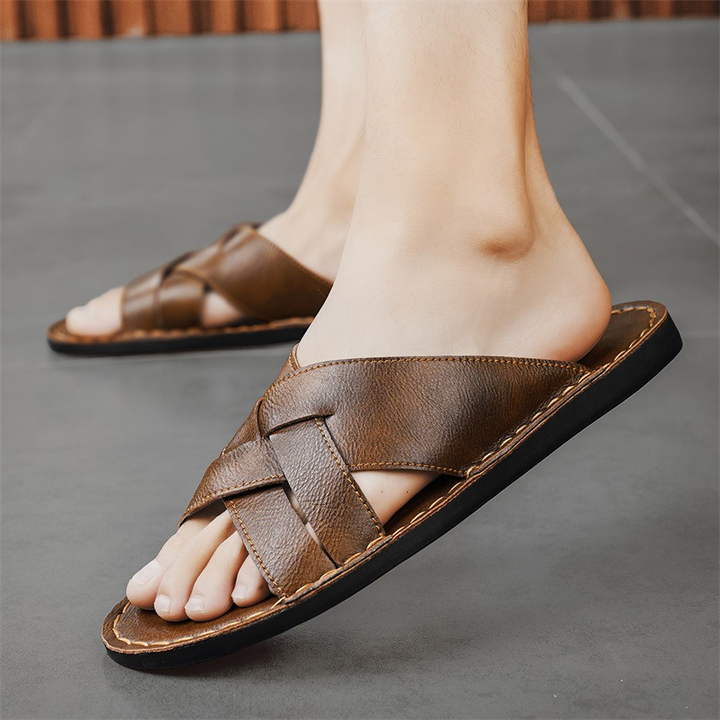Open-toe men's slide sandals with a comfortable cross-strap and cushioned sole for leisure.
