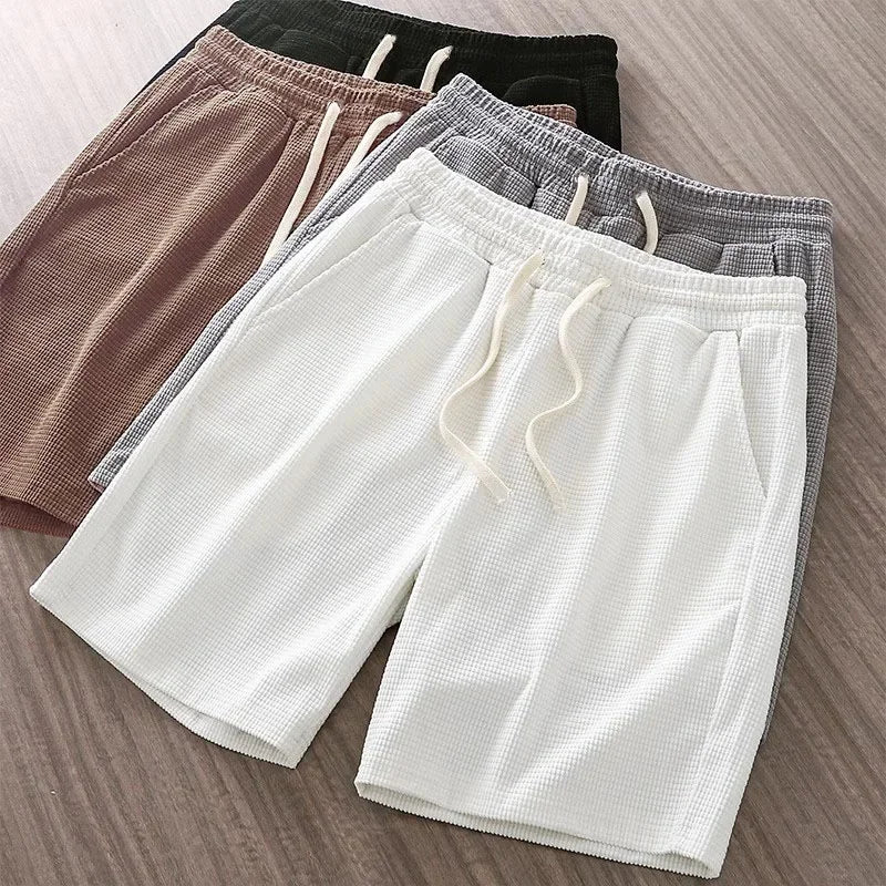 Relaxed fit men's waffle knit lounge shorts featuring a drawstring waist & convenient pockets. Ideal summer attire.