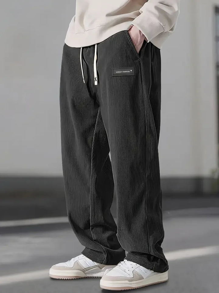 Close-up of the rich corduroy fabric texture on men's cargo trousers, emphasizing quality & durability.