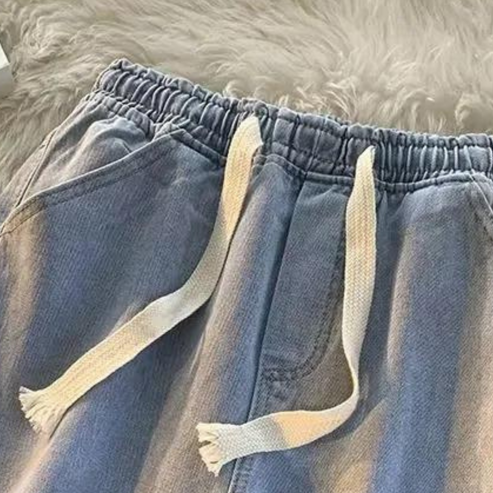 Stylish men's denim jogger pants featuring an elastic waist & drawstring for ultimate comfort & streetwear.