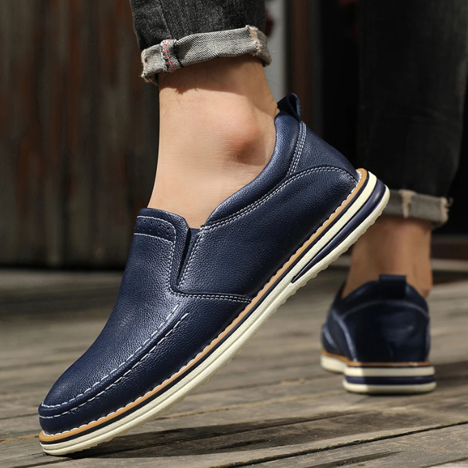 Detailed view of men's Cooper Mocs loafers, showcasing quality leather texture & classic moc toe stitching.