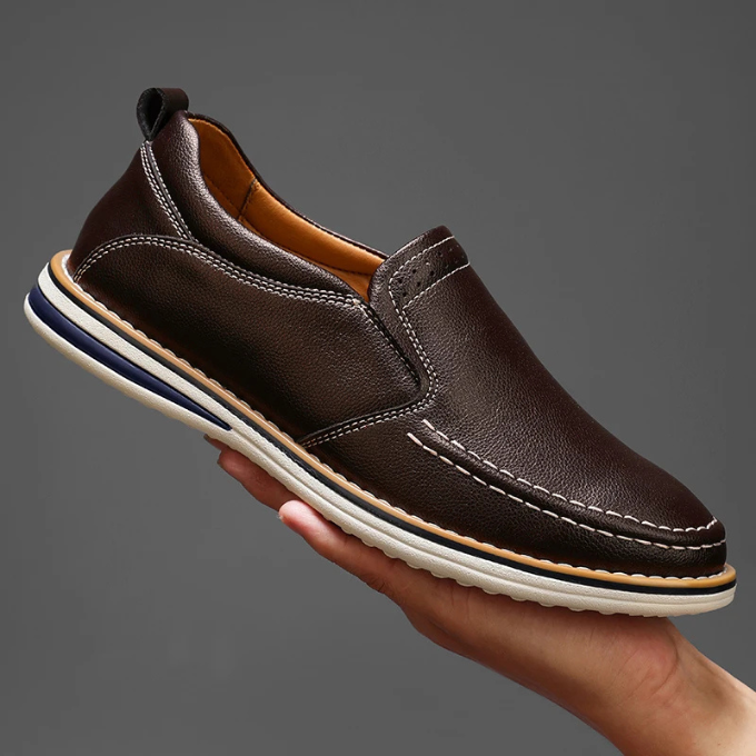 Man wearing men's Cooper Mocs loafers while sitting, showcasing relaxed & stylish everyday footwear. Classic loafers.