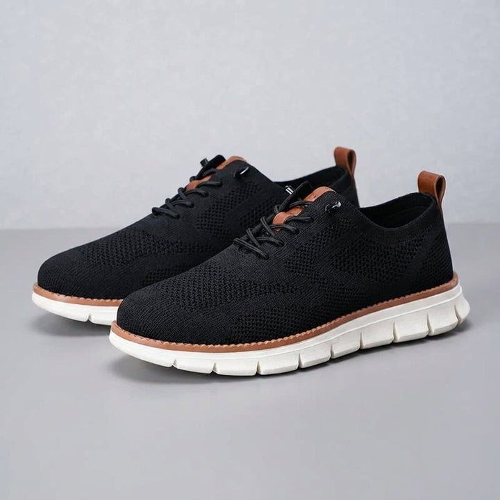Pair of black men's Damon breathable trainers on a white background, emphasizing athletic design.