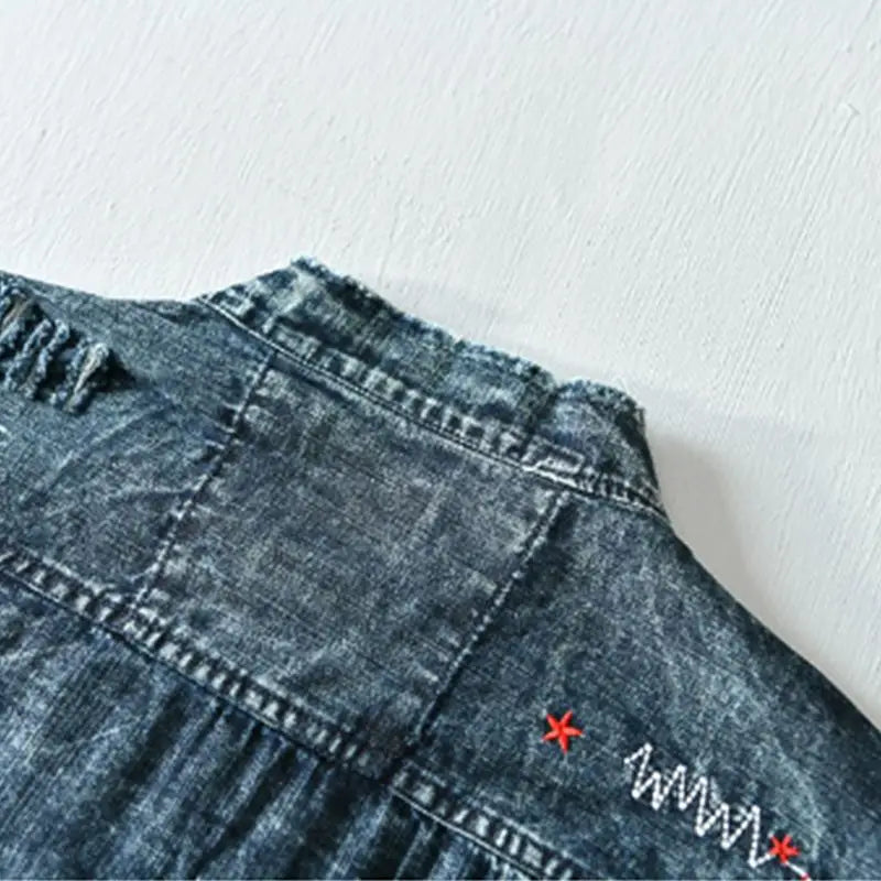 Distressed men's denim shirt. Edgy collarless, raw hem, light blue. Modern fit for fashion-forward men.