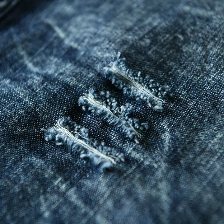 Front view of a men's edgy blue denim shirt with sharp collarless cut and distinct raw hems. Long sleeve.