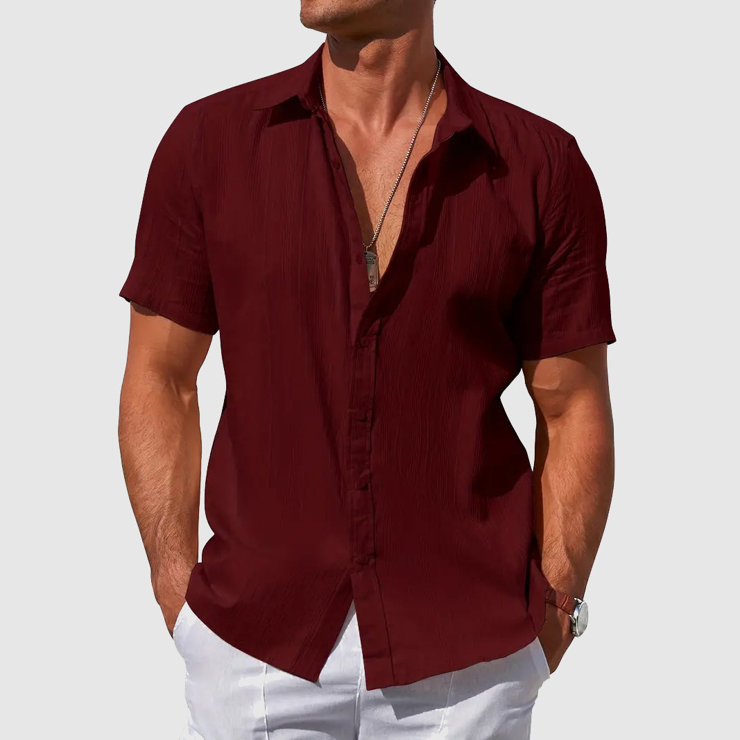Man in a relaxed fit short-sleeve summer shirt, styled for casual outings. Effortless men's warm weather fashion.