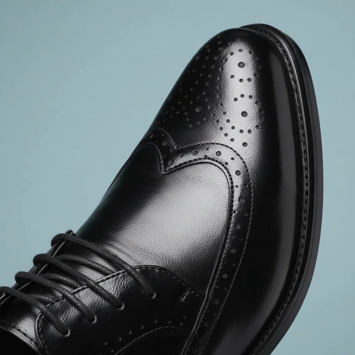 Close-up of men's elegant black leather shoe, showcasing fine craftsmanship and smooth finish.
