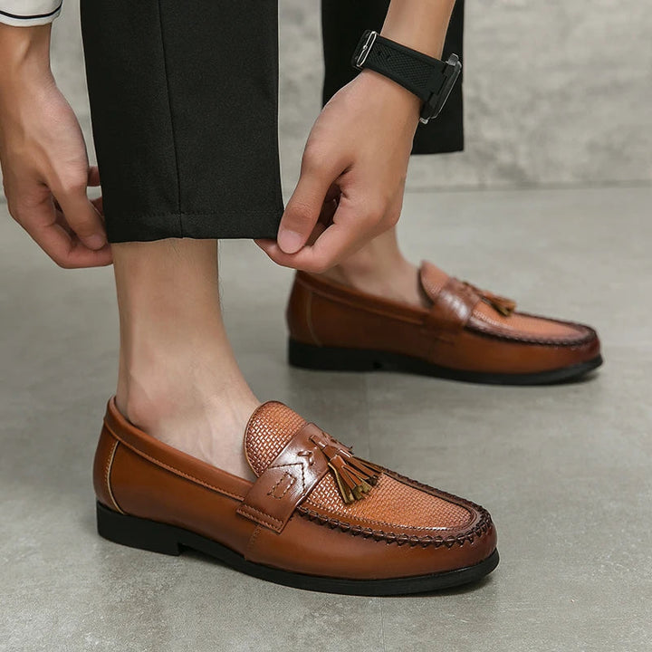 Elegant men's woven loafers featuring decorative tassels. Comfortable slip-on footwear for dressy or casual style.