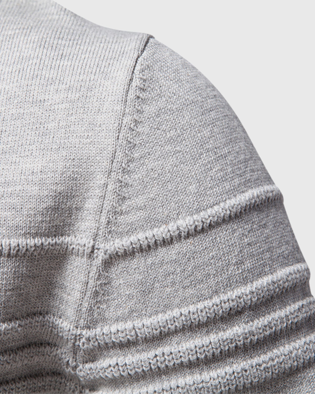 Full shot of a man wearing a grey textured crew sweater for versatile everyday style.