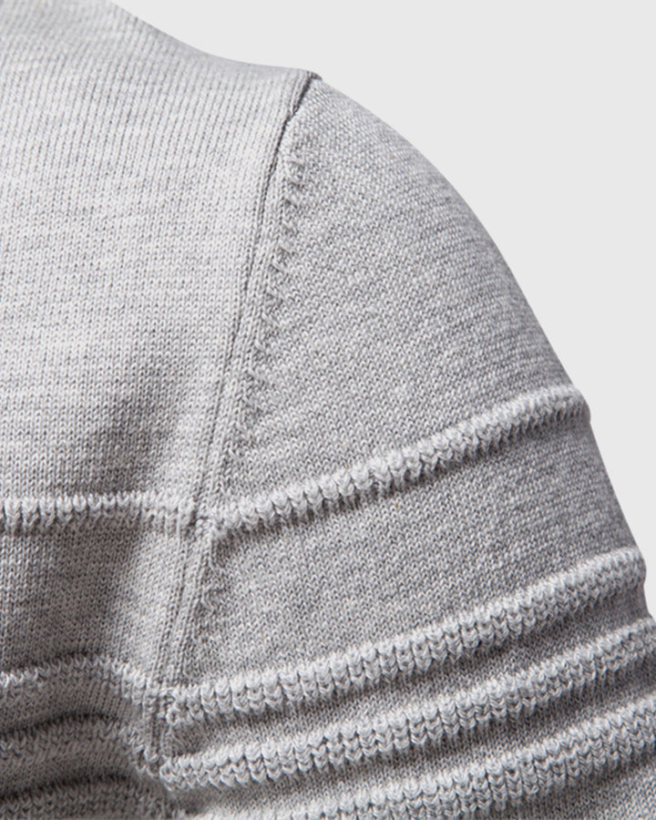 Full shot of a man wearing a grey textured crew sweater for versatile everyday style.