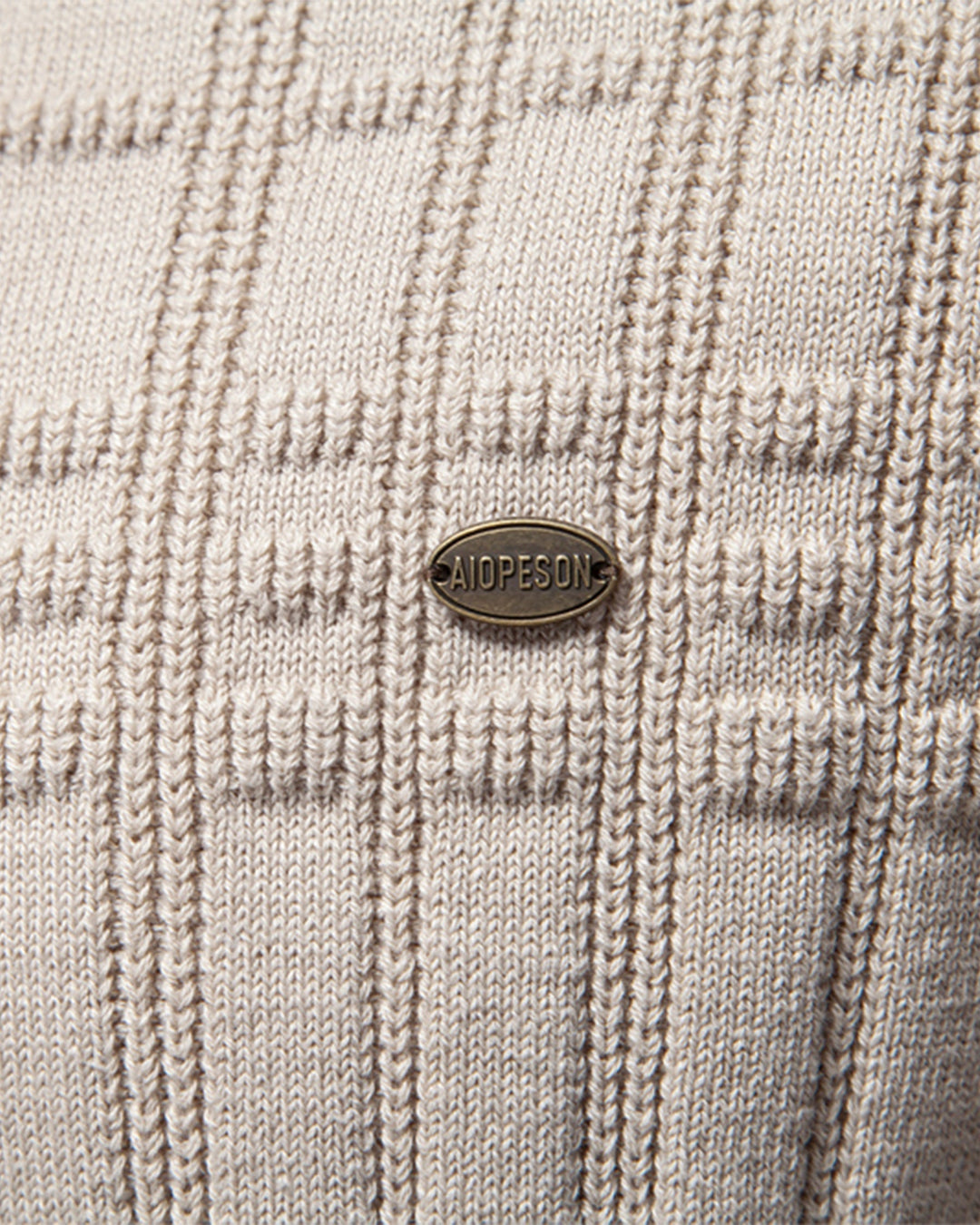 Close-up on the hem of the men's elevated textured knit crewneck sweater.