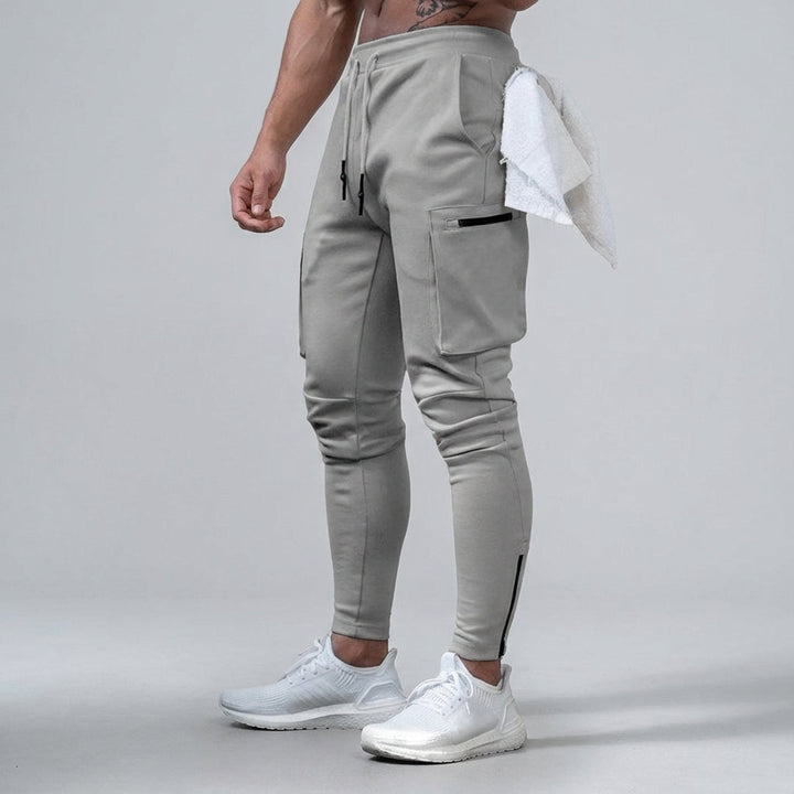 Close-up of men's tapered fit gym pants, showing stretch fabric detail and Ernest branding