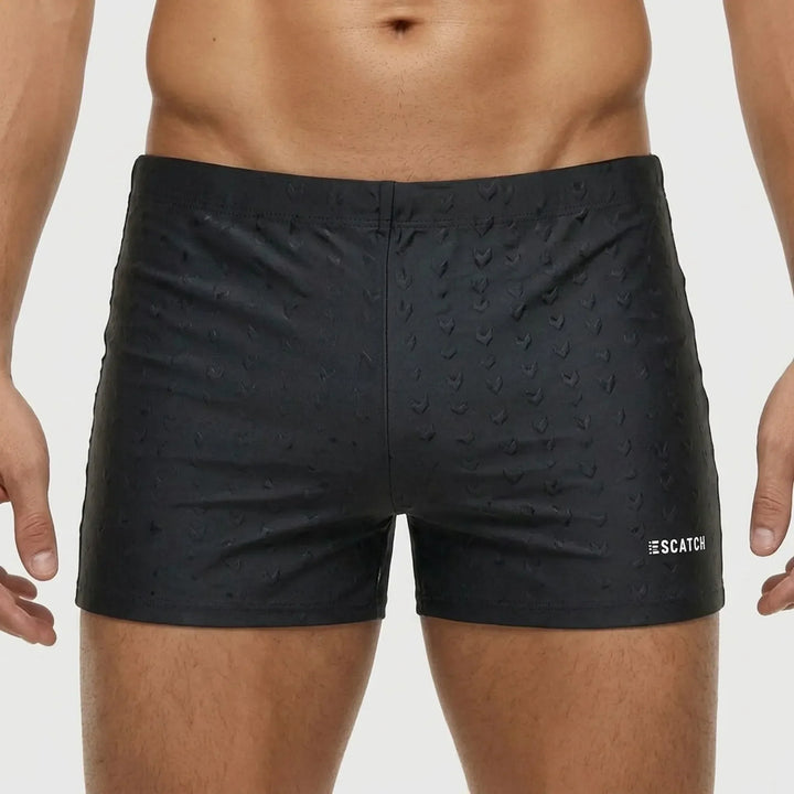 Man enjoying the beach in fitted athletic swim trunks, showcasing freedom of movement for active wear.