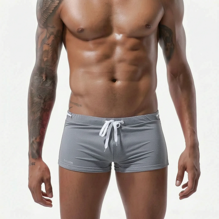 Modern mens low-rise fitted swim trunks, perfect for athletic swimwear & beachwear.