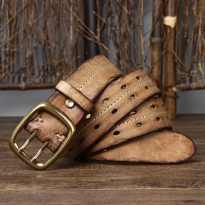 Detail shot of a men's full-grain leather belt showcasing the solid brass buckle and fine leather craftsmanship.