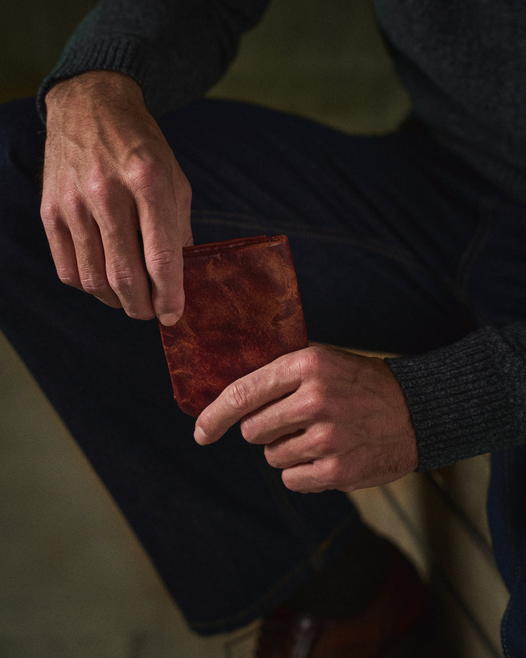 Open dark brown full-grain leather men's wallet revealing multiple card slots and coin pocket.