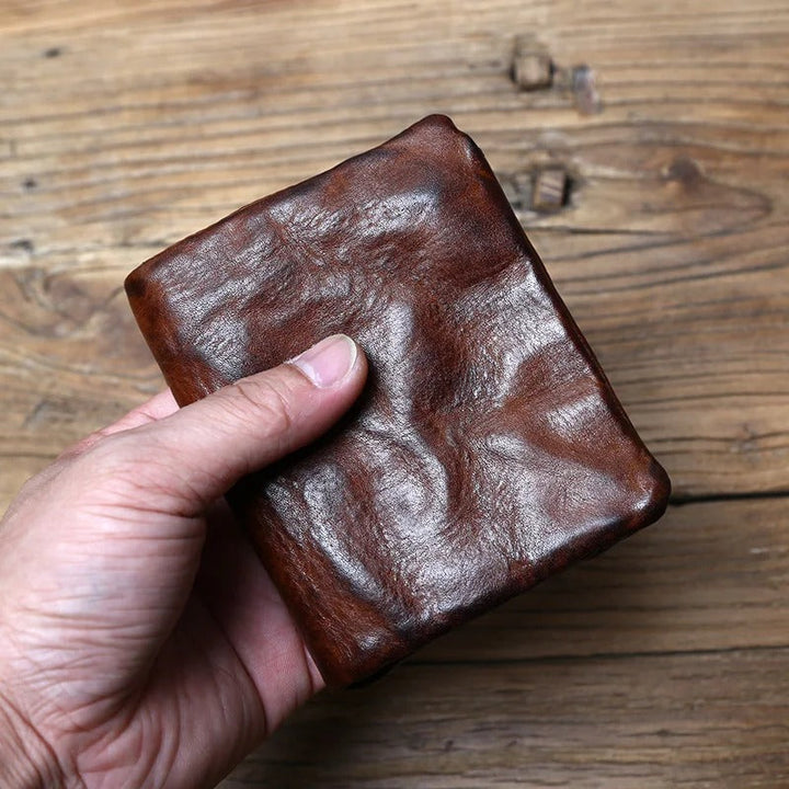 Angled shot of a dark brown full-grain leather men's wallet, highlighting its compact, bifold design.