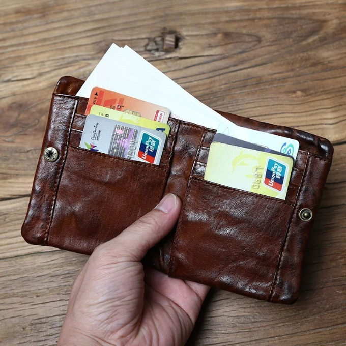 Stylish full-grain leather men's wallet resting on a wooden desk, ready for everyday use and errands.