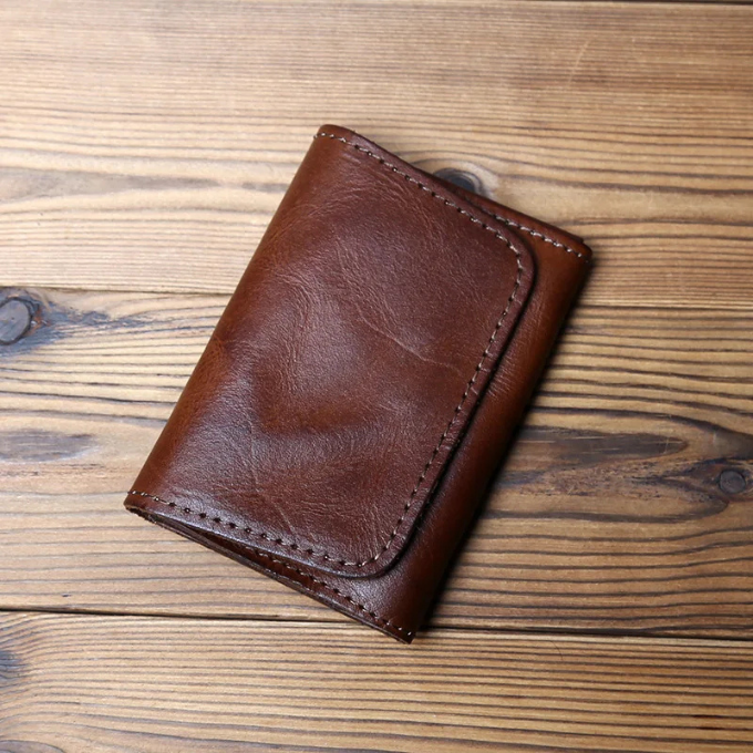Stylish men's tri-fold wallet, full-grain aged leather. A classic, durable accessory.