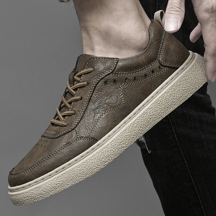Stylish men's genuine leather perforated sneakers, ideal casual footwear for a modern, comfortable look.
