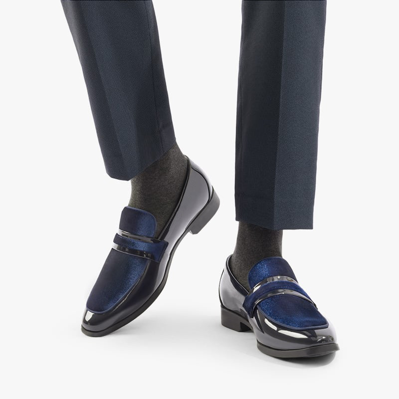 Stylish men's glossy navy dress loafers worn, perfect modern formal footwear for elegance & comfort.