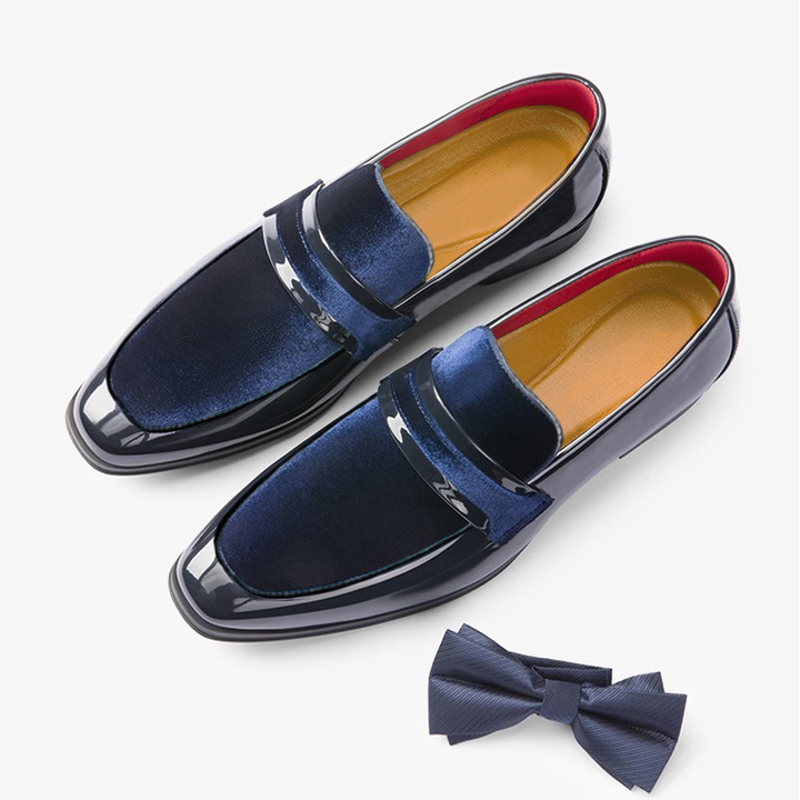 Men's glossy black dress loafers paired with a suit, ultimate modern formal occasion wear.