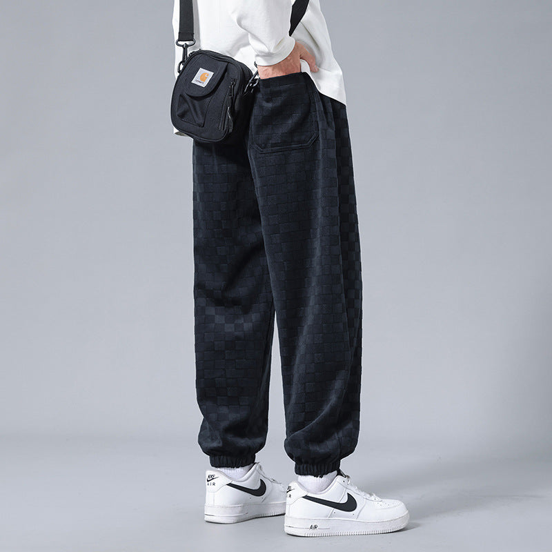 Relaxed fit men's checkerboard activewear sweatpants in black & cream, combining comfort & style.