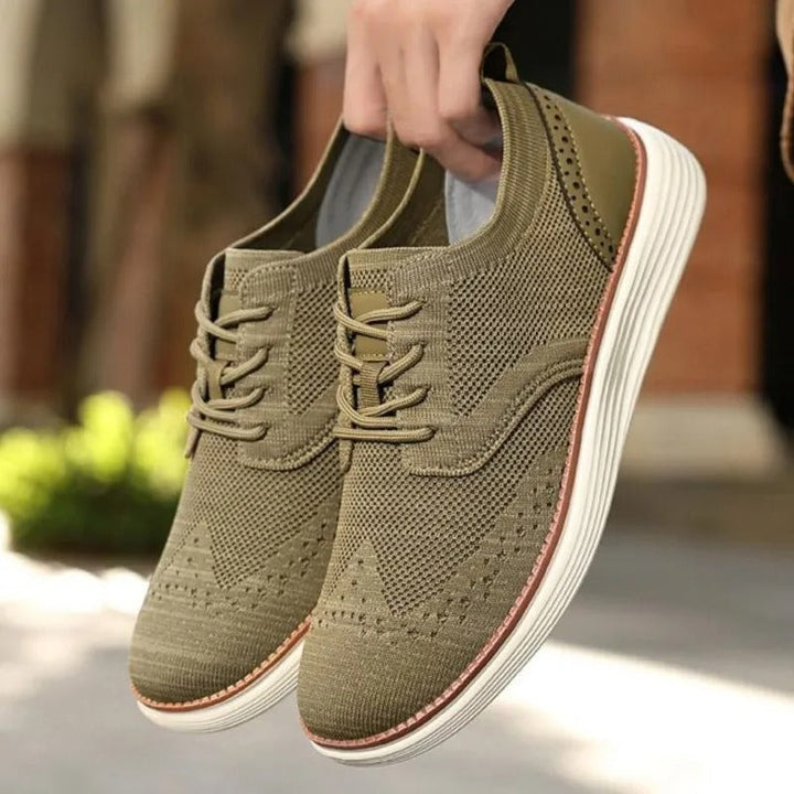 Lace-up men's hybrid dress sneakers, wingtip design for versatile fashion.