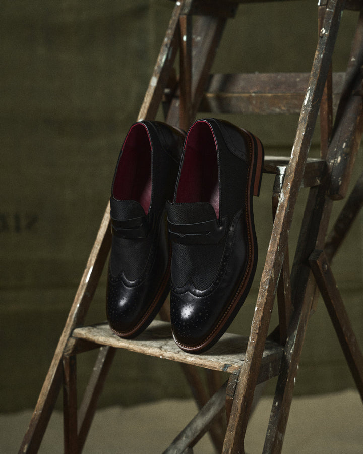 Navy men's hybrid slip-on loafers with a distinctive wingtip design for modern dress casual footwear.