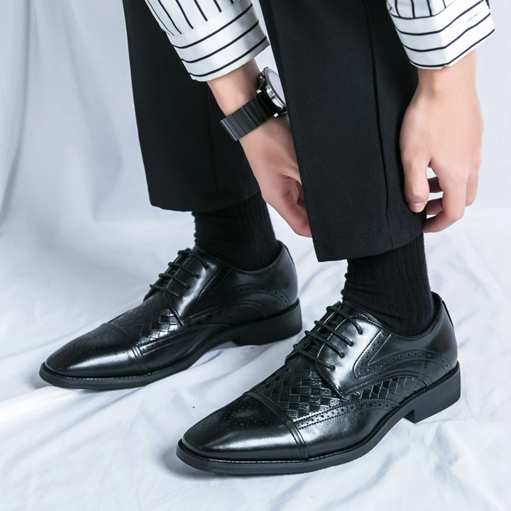 Polished men's Kensington brogue dress shoes reflecting light, emphasizing their luxurious and sophisticated finish.