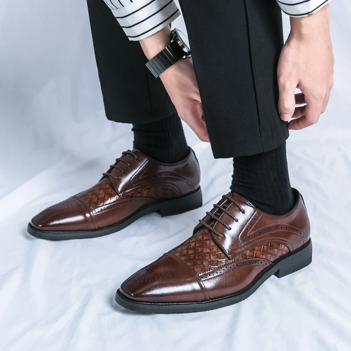 Detailed shot of the unique brogue patterns on men's formal oxford shoes, highlighting classic footwear style.