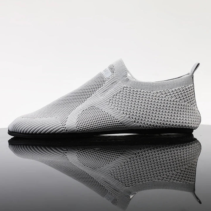Men's black knit slip-on shoes. Lightweight, breathable, flexible design for barefoot comfort.