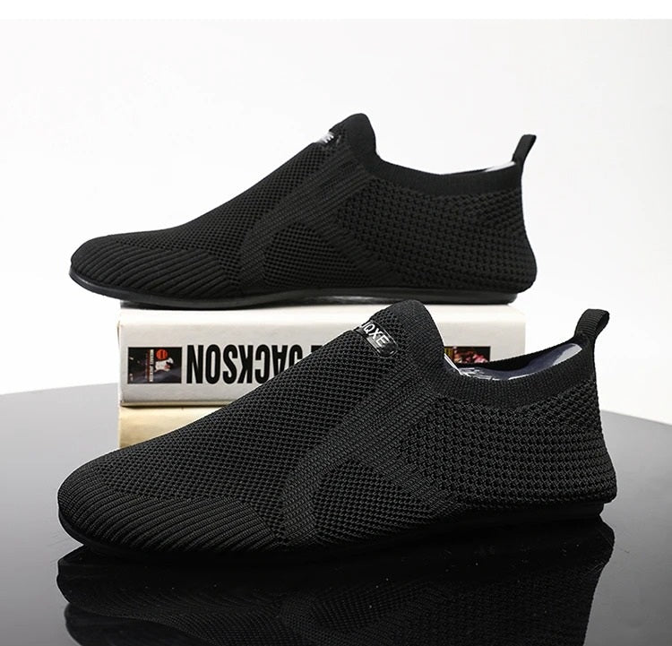 Top view of black men's knit slip-on shoes. Barefoot comfort, breathable fabric, laceless.