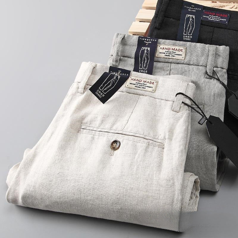 Detail shot of men's tapered linen trousers, highlighting the breathable fabric, lightweight design, and quality for summer.