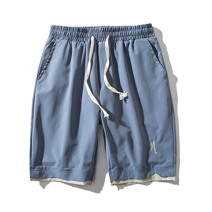 Close-up of the fabric texture of men's lightweight performance shorts with pocket detail.