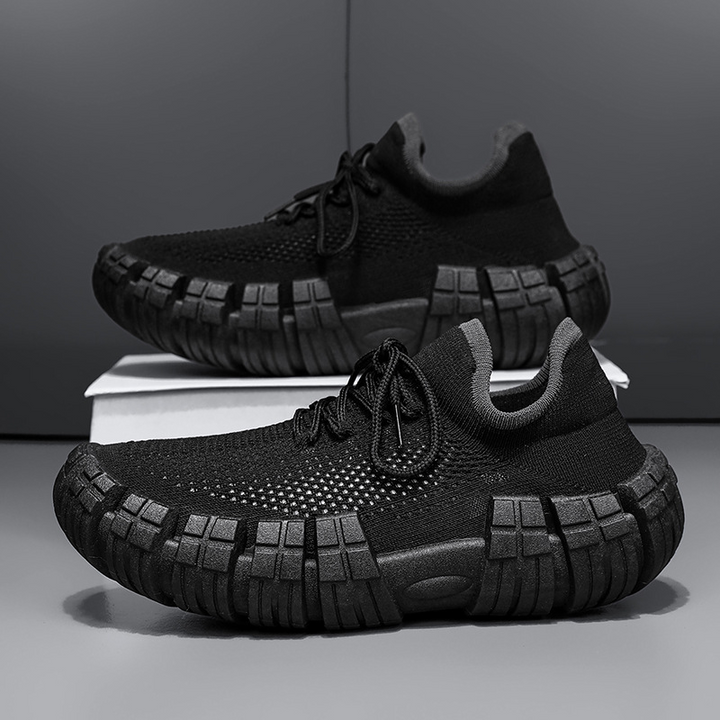 Man wearing black lightweight urban agility sneakers, walking comfortably in a city environment.