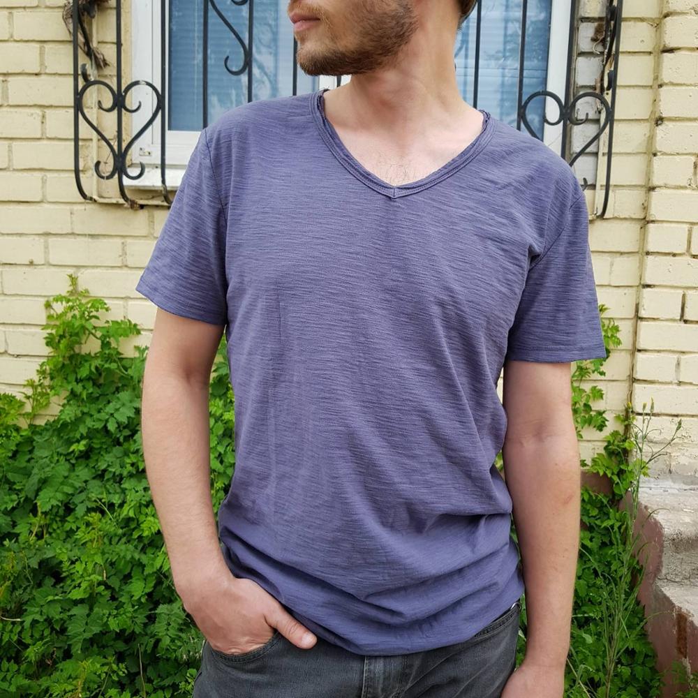 Folded white V-neck linen blend shirt, showcasing its lightweight and soft material